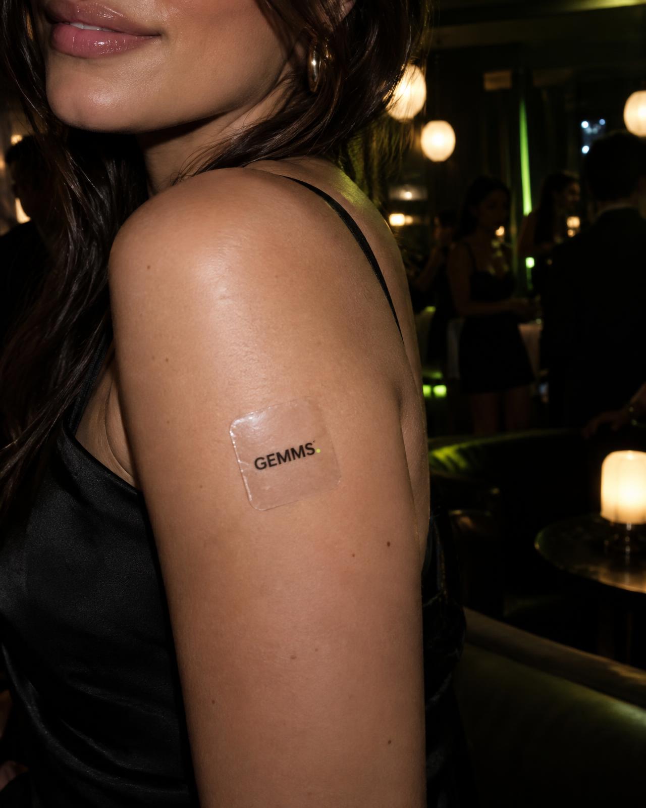Transparent Gemms patch worn on the upper arm during a night out